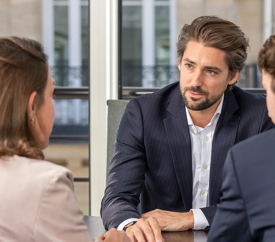 Un conseiller échangeant avec des clients autour d'une table, lors d'une réunion